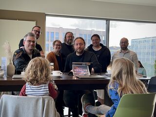 Photo of Homebrew Website Club Düsseldorf participants with laptops gathered around a table in a cafe